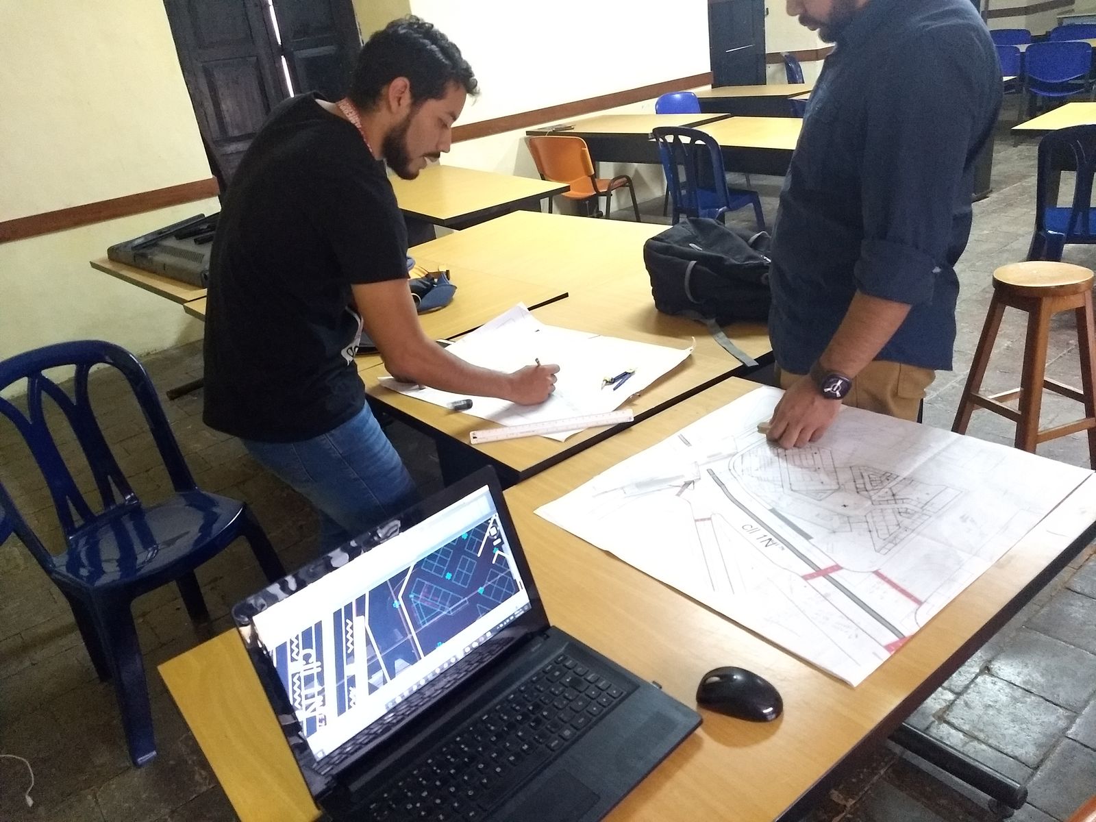 Equipo trabajando sobre planos en mesa de taller